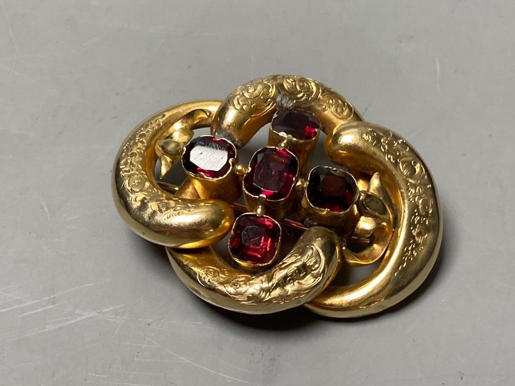 A Victorian engraved yellow metal and five stone garnet set openwork scroll brooch (a.f.)